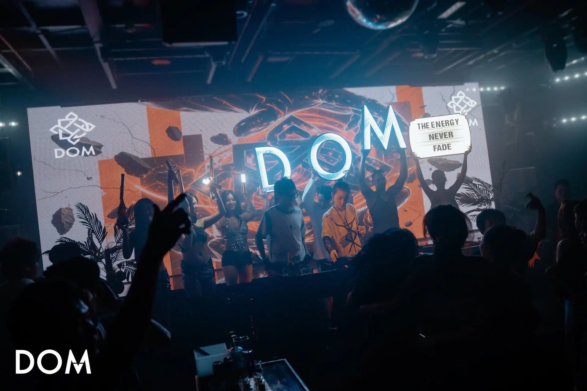 Tường LED chữ DOM khổng lồ cùng bảng The Energy Never Fade, nghệ sĩ và vũ công đứng trên sân khấu